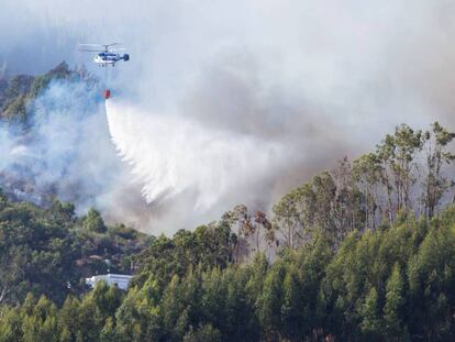 Un helicóptero realiza labores de extinción en la localidad de Guía.