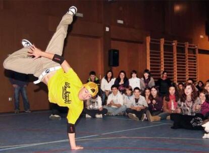 Uno de los <i>b-boys</i> practica el baile denominado <i>breakdance</i> ante la expectación de alumnos de los institutos de Ferrol.