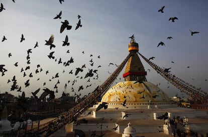 Las palomas vuelan alrededor de la Stupa de Boudhanath, patrimonio de la humanidad, cuando los devotos realizan rituales en el último día del Losar tibetano, o el Año Nuevo, en Katmandú (Nepal).