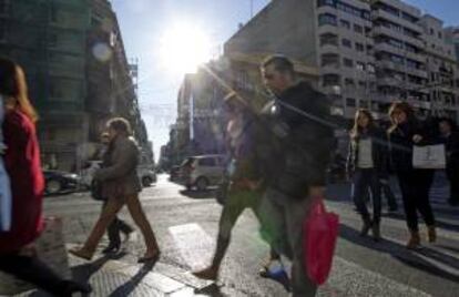 Varias personas cruzan la céntrica calle Colón de Valencia, una de las más comerciales de la ciudad. EFE/Archivo