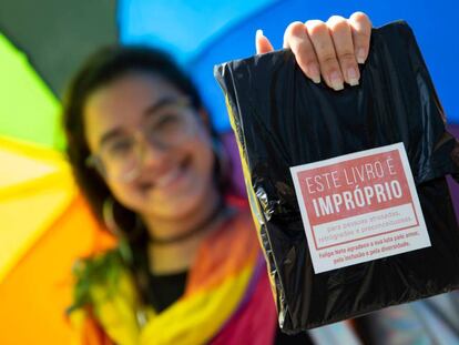 Una mujer muestra uno de los ejemplares regalados por el youtuber el sábado en la Bienal de Río.