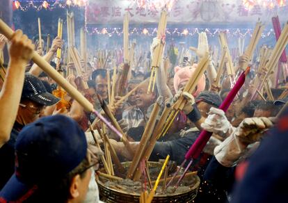 La gente se apresura a plantar su incienso de Año Nuevo en el templo Kwan Im Thong Hood Cho de Singapur, el 4 de febrero de 2019.
