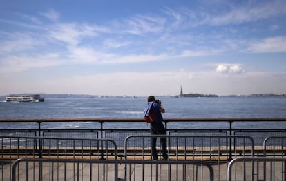 Un turista toma una fotograf&iacute;a de la estatua de la Libertad.