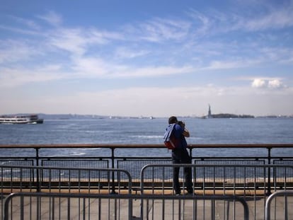 Un turista toma una fotograf&iacute;a de la estatua de la Libertad.