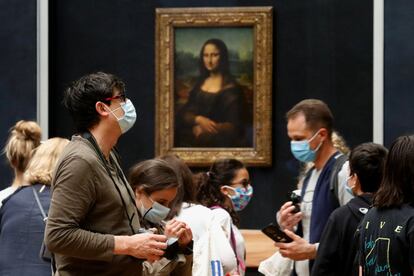 Visitantes con mascarillas, frente a la 'Mona Lisa', de Leonardo da Vinci, en el museo del Louvre en París, en la reapertura al público después de casi 4 meses de cierre debido a la pandemia del coronavirus.