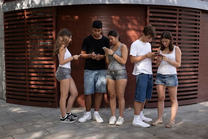 Un grup de joves, protagonistes de les alarmes digitals, miren les pantalles dels seus aparells.