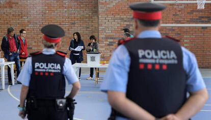 Una pareja de los Mossos, el domingo en un colegio electoral en Figueres.