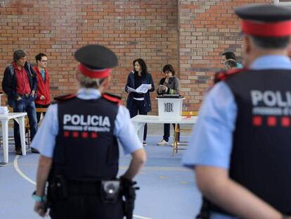 Una pareja de los Mossos, el domingo en un colegio electoral en Figueres. 