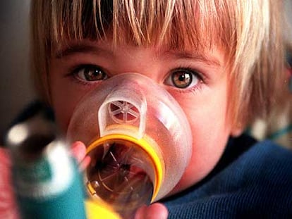 Una niña con asma se medica con inhaladores.
