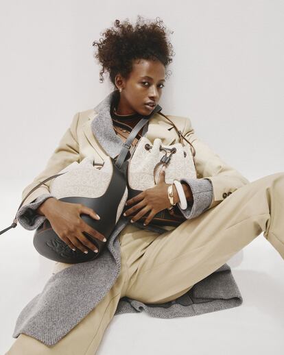 Abrigo de lana gris de Herno, traje de algodón beis de Lacoste, brazaletes oro y blanco de Helena Rohner, gargantilla de eslabones de Rabat, pendientes de oro de Suarez y bolsos modelo Balloon, de Loewe (en dos tamaños).
