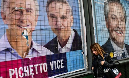 Una mujer pasa por delante de carteles de propaganda de Mauricio Macri y Alberto Fernández en una calle de Buenos Aires.