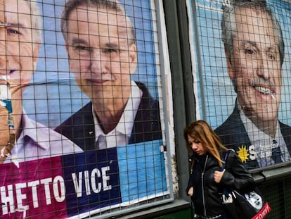 Una mujer pasa por delante de carteles de propaganda de Mauricio Macri y Alberto Fernández en una calle de Buenos Aires.