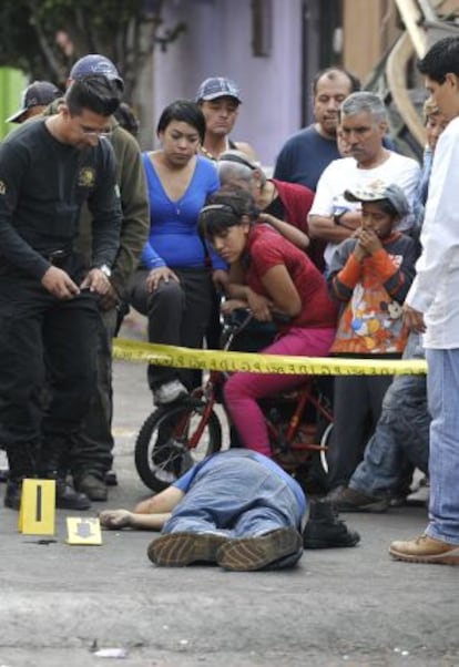 Peritos forenses y agentes policiales realizan el levantamiento de un cadáver en Iztapalapa (Ciudad de México).