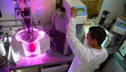 Un investigador del Grupo de Biotecnología de la Universidad de Antioquia aplica iluminación LED a un biorreactor con cacao.