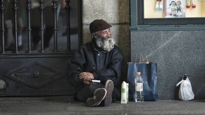 Un mendigo, un hombre mayor, pide limosna en los soportales de la plaza Mayor de Madrid.