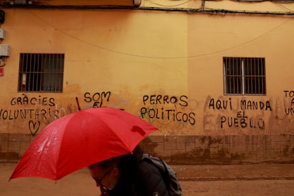 Un hombre pasaba el mircoles junto a unas pintadas en Paiporta (Valencia).