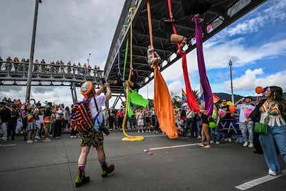 Mujeres cuelgan con telas desde un puente para realizar una coreografía aérea, este 2 de junio en Bogotá.