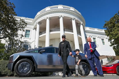 Donald Trump, Elon Musk and Musk’s son make a press appearance in front of two Telsa cars.