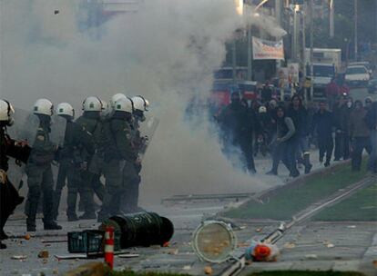 Policías y manifestantes se enfrentan cerca del cementerio (arriba) tras el entierro de Alexandros Grigoropulos.