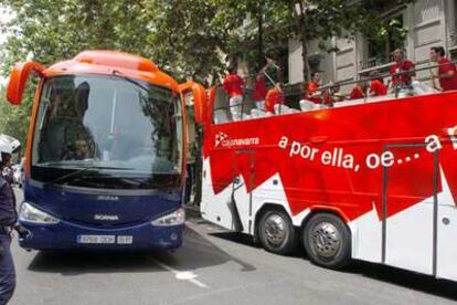 El autocar de Osasuna, vigilado por la policía, pasa junto a otro ocupado por hinchas del equipo.