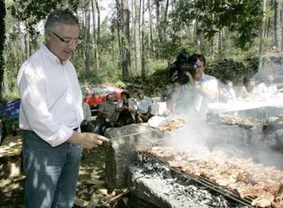 José Blanco cocina churrasco en la fiesta-mitin celebrada ayer en Muxía.