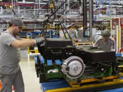 Dos operarios colocan unas baterías en una furgoneta eléctrica de Citroën en la cadena de montaje de la planta de PSA. EFE/Archivo