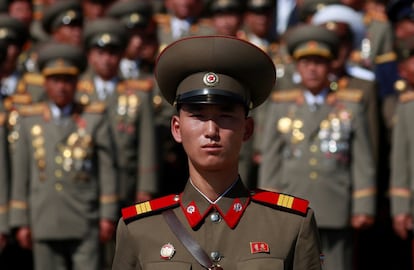 Un soldado porta una insignia con retratos de los líderes norcoreanos Kim Il Sung y Kim Jong Il.