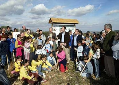 Francisco Camps y Rafael Blasco rodeados de escolares en el monte de Sant Antoni, en Llombai, ayer.