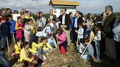 Francisco Camps y Rafael Blasco rodeados de escolares en el monte de Sant Antoni, en Llombai, ayer.