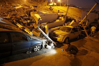 Un hombre graba los destrozos de unos vehículos en la Iquique (Chile), 2 de abril.