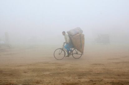 Un hombre en su bicicleta entre la niebla en Lahore (Pakistán).
