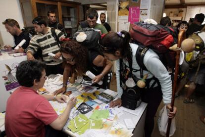 Decenas de peregrinos sellan su cartilla al llegar a Santiago de Compostela.