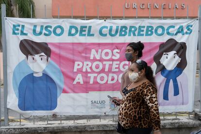 Habitantes de la Ciudad de Campeche caminan frente a un aviso sobre la covid.