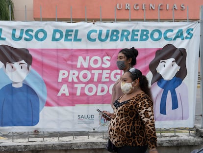 Habitantes de la Ciudad de Campeche caminan frente a un aviso sobre la covid.