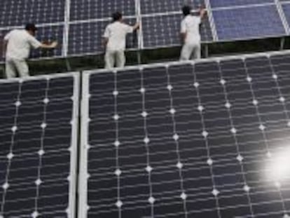 Trabajadores colocan paneles solares en Baoding (China). 