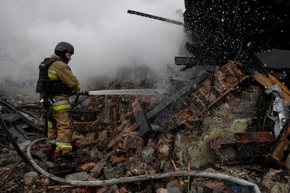 Un bombero apaga un incendio registrado en un edificio dañado durante el ataque ruso a Ucrania, este miércoles en Járkov.