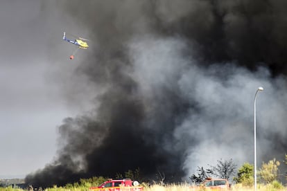 Un helicóptero ayuda en las labores de extinción del incendio.