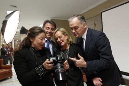 Esteban González Pons (a la derecha), junto a los también diputados del PP Belén Juste Picón (a su lado) y Manuel Cervera Taulet, observando las fotografías que les han hecho para la acreditación del Congreso.