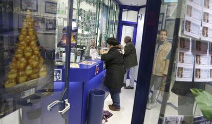 Varias personas compran lotería de Navidad en una administración de San Sebastián.