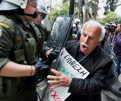 Un pensionista intenta romper la barrera de seguridad durante la protesta ayer en Atenas (Grecia) contra las medidas de ajuste.