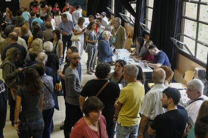 Colas de ciudadanos esperan su turno para votar en un colegio electoral de Barcelona.