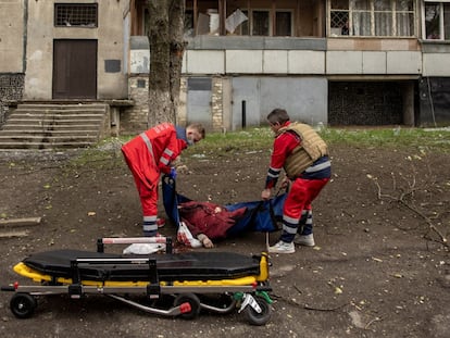 Trabajadores médicos recogen el cuerpo de una mujer, después de un bombardeo ruso en Járkov (Ucrania).