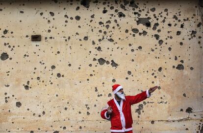 Irak declaró la victoria sobre los yihadistas a mediados de diciembre de 2017, si bien los daños causados a los enclaves cristianos fueron amplios. En la foto, uno de los Papa Noel que reparte regalos por Mosul, frente a una pared con marcas de metralla.