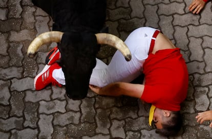 Un astado de Fuente Ymbro pasa por encima de un corredor, este miércoles durante el cuarto encierro de San Fermín. 