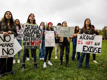 Women hold up signs with myths about rape during a 2021 protest for victims of sexual assault in Bloomington, Indiana.