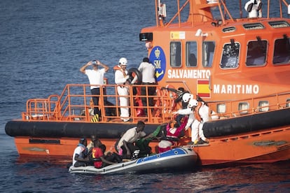 Trabajadores de Salvamento Marítimo ayudan a embarcar a once migrantes que cruzaban en un bote de plástico a remos el Estrecho. Eran diez varones y una mujer subsaharianos. Las balsas como esta de playa son frecuentes.