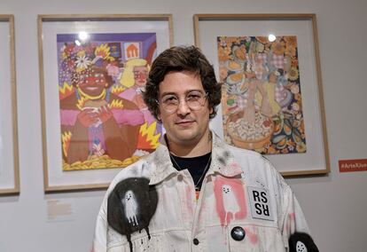 El artista Ricardo Cavolo posa frente a su obra, en la que Marsha P. Johnson y Sylvia Rivera disfrutan de comida rápida.