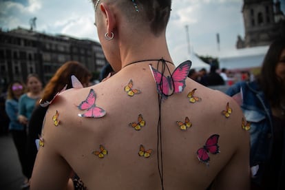 Un hombre muestra su espalda con mariposas de papel antes del concierto de la cantante española Rosalía, en el Zócalo de la Ciudad de México, el 28 de abril de 2023.