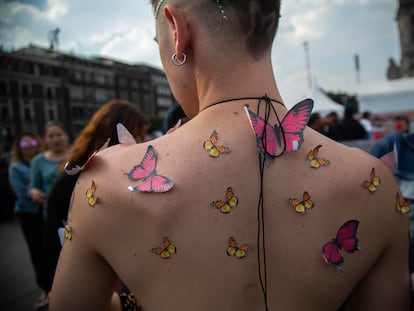 Un hombre muestra su espalda con mariposas de papel antes del concierto de la cantante española Rosalía, en el Zócalo de la Ciudad de México, el 28 de abril de 2023.