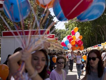 Unas animadoras infantiles regalan globos a los niños durante la Feria del Libro de Madrid.